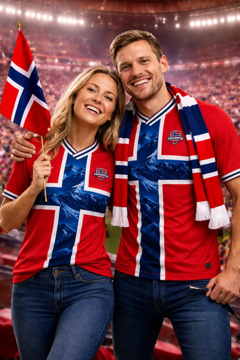 Smilende par i norske supportertrøyer med flagg og skjerf på fotballstadion – bestselgere fra Fanshoppen.no