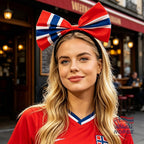 Fanshoppen Norge headband with a large red, white, and blue bow in the Norwegian flag colors. A blonde woman wears it with a red jersey.
